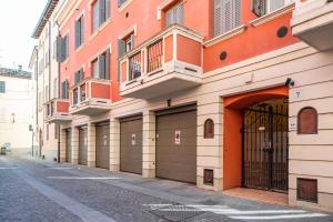 un edificio naranja con puertas de garaje en una calle en Officina7 Large en Parma