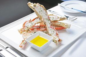 a white plate with a pile of shrimp and a bowl of mustard at Alyeska Resort in Girdwood