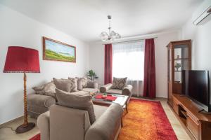 sala de estar con sofá y TV en Topáz Apartmanházak Keszthely en Keszthely