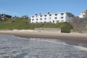 einen Strand mit einem weißen Gebäude auf einem Hügel in der Unterkunft West Beach Suites in Lincoln City