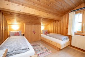 a bedroom with two beds in a wooden cabin at Streidlhof in Lenggries
