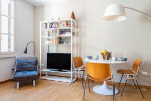 ein Wohnzimmer mit einem Tisch und Stühlen sowie einem TV in der Unterkunft Officina7 Large in Parma