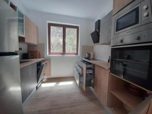 a kitchen with wooden cabinets and a window at Captain Ante's House in Dragove