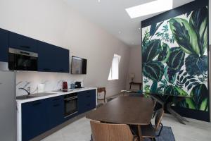 a kitchen with blue cabinets and a wooden table at Champagne André Bergère - Guest House in Épernay