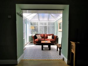 uma sala de estar com um sofá vermelho e uma mesa em Romantic Cottage with Private Hot Tub em Llanfyrnach