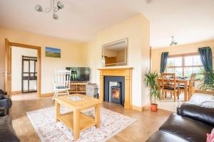 a living room with a fireplace and a table at Bin Mountain Self Catering in Castlederg