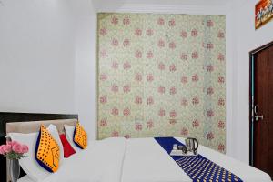 Schlafzimmer mit einem Bett mit orangefarbenen und blauen Kissen in der Unterkunft SPOT ON Hotel Srb in Jodhpur