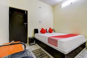 a bedroom with a bed with red pillows at Hotel Basera in Bankipur