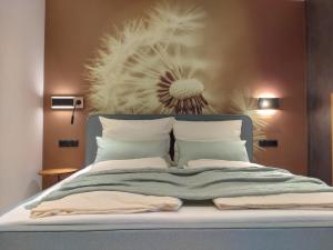 a bedroom with a bed with a flower on the wall at Aenna Apart Prutz in Prutz