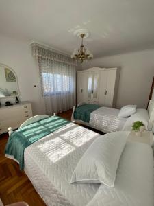 a bedroom with two beds and a chandelier at Casa Teresa in Redondela
