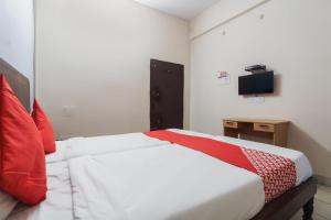 a bedroom with a white bed with a red blanket at OYO Hotel Regal Near Paradise Circle in Secunderabad