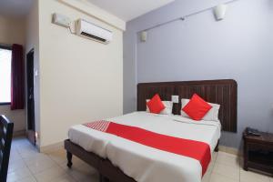 a bedroom with a large bed with red pillows at OYO Hotel Regal Near Paradise Circle in Secunderabad