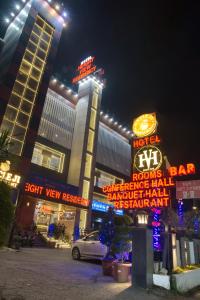 a building with neon signs in front of it at night at Height View Residency in Dehradun
