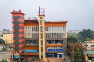 a tall building with a red and white at Height View Residency in Dehradun
