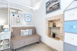 a small room with a chair and a book shelf at Vico di Ostuni Apartments by Rentbeat in Ostuni