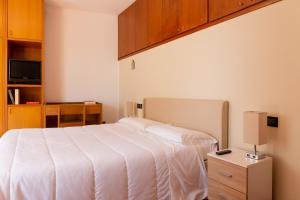 - une chambre avec un grand lit blanc et une table de nuit dans l'établissement Albergo Sacro Monte Varese, à Varèse