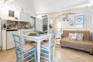 cocina y comedor con mesa y sillas en Vico di Ostuni Apartments by Rentbeat, en Ostuni