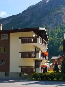 a building with balconies and a mountain in the background at Appartement Arve in Saas-Almagell