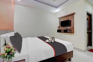 a hotel room with a bed and a tv at Collection O Hotel Premnagar Heights in Dehradun