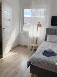 a bedroom with a bed and a window at Apartamenty Zatorze in Leszno