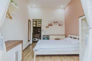 1 dormitorio con 1 cama blanca en una habitación en Laca homestay en Gia Nghĩa
