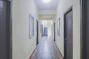 a hallway with white walls and a long hallway with doors at Flagship Sri Residency in Dhundgol