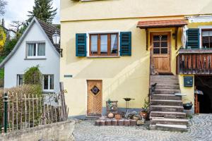 Casa amarilla con puerta de madera y escaleras en Fischerstube, en Sipplingen