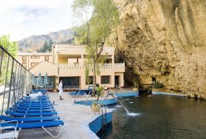 a resort with a pool with blue chairs in the water at Hotel Balneario de La Virgen in Jaraba