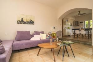 een woonkamer met een paarse bank en een tafel bij Villa Memories in Palaiochóra