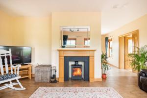 a living room with a fireplace and a television at Bin Mountain Self Catering in Castlederg