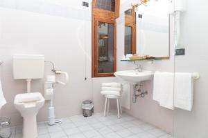a bathroom with a toilet and a sink and a mirror at Albergo Sacro Monte Varese in Varese