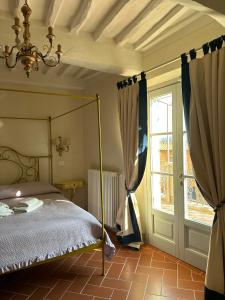Castellinaria في Lari: غرفة نوم مع سرير مظلة ونافذة