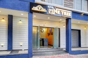 a blue and white building with a sign for a pine tree at Townhouse Hotel Pine Tree in Indore