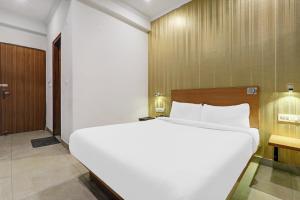 1 cama blanca grande en una habitación de hotel en Townhouse Rama Inn. en Vibhuti Khand