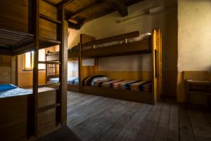 2 literas en una habitación con suelo de madera en Ostello Podesteria di Gombola - arte e territorio, en Polinago