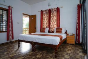 AnachalにあるOYO M S Holiday Resortのベッドルーム1室(赤いカーテン付きの大型ベッド1台付)