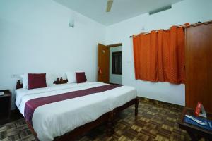 AnachalにあるOYO M S Holiday Resortのベッドルーム1室(赤いカーテン付きの大型ベッド1台付)