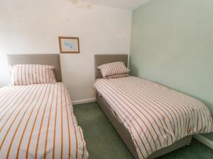 dos camas sentadas una al lado de la otra en un dormitorio en Sea View Cottage, en South Shields