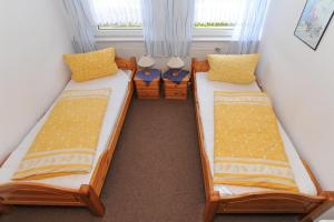 - 2 lits jumeaux dans une chambre avec fenêtre dans l'établissement Janssen Ferienwohnungen, à Leybuchtpolder