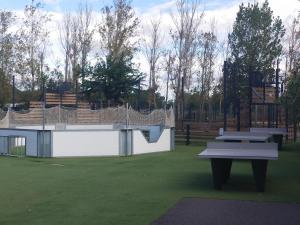 瓦爾拉普拉日的住宿－MOBIL HOME LE LOZERIEN，公园,设有两张野餐桌和一个击球笼