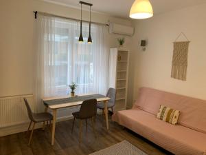 ein Wohnzimmer mit einem Tisch und einem Sofa in der Unterkunft BEAUTY APARTMAN CORVIN in Budapest