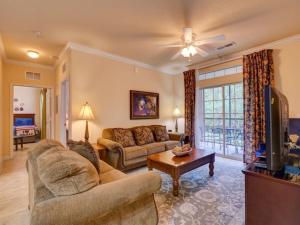 a living room with a couch and a tv at Disney Memories at Tuscana Resort in Kissimmee