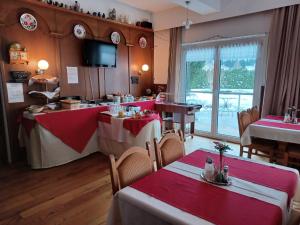 バート・ミッテルンドルフにあるRetro Hotel Igelheimの赤と白のテーブルクロスを用いたテーブル席のあるレストラン