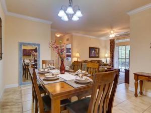 a dining room and living room with a table and chairs at Disney Memories at Tuscana Resort in Kissimmee
