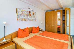 1 dormitorio con 1 cama con almohadas de color naranja en Ferienwohnung Lindau en Sipplingen