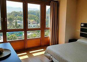 利亞內斯的住宿－Apartamentos Camparina，一间卧室设有一张床和一个大窗户