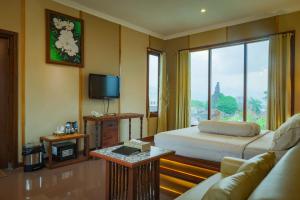 Cette chambre comprend un lit et une télévision. dans l'établissement Family Hotel Gradia 2, à Batu