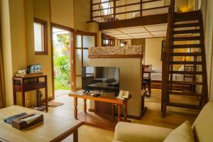 a living room with a tv and a loft at Family Hotel Gradia 2 in Batu