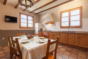 a kitchen with a table with chairs and a kitchen with at El Cup in San Martín de Tous