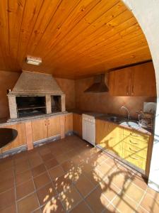 a kitchen with wooden ceilings and a stove top oven at Casa Teresa in Redondela